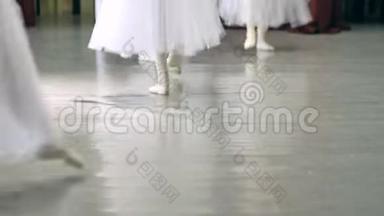 芭蕾。 在芭蕾训练中，女孩`穿白色芭蕾舞鞋的腿。 古典舞的元素。